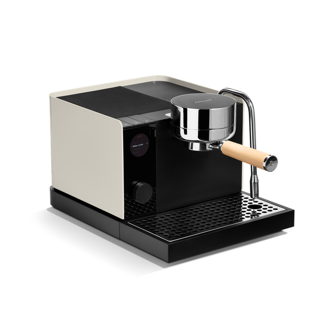 A sleek espresso machine with a cream-colored side panel, black body and drip tray, a polished stainless steel portafilter with a light wood handle, and a black water tank, shown on a clean white background.